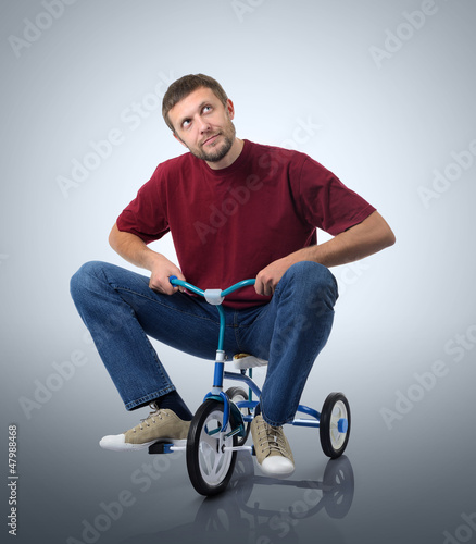 Photo: Dreams of a man on a children's bicycle Dreams of a man on a children's bicycle