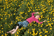 Mädchen liegt in einer Blumenwiese