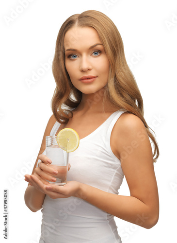 Photo: woman with lemon slice on glass of water woman with lemon slice on glass of water