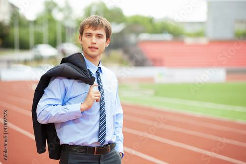 Photo: Businessman at athletic stadium and race track Businessman at athletic stadium and race track