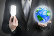 Businessman holding a light bulb and planet Earth.