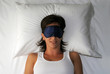 Mujer durmiendo descansando con tapa ojos.en una cama