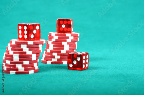 Photo: Poker gambling chips on a green playing table Poker gambling chips on a green playing table