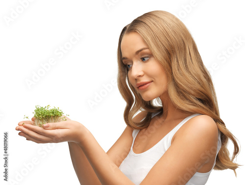 Photo: woman with green grass on palms woman with green grass on palms