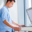 Photo: Handsome young man using a copy machine Handsome young man using a copy machine