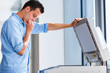 Photo: Handsome young man using a copy machine Handsome young man using a copy machine