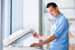 Photo: Handsome young man using a copy machine Handsome young man using a copy machine