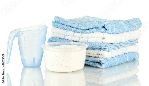Photo: measuring cups with washing powder and towels, isolated on measuring cups with washing powder and towels, isolated on