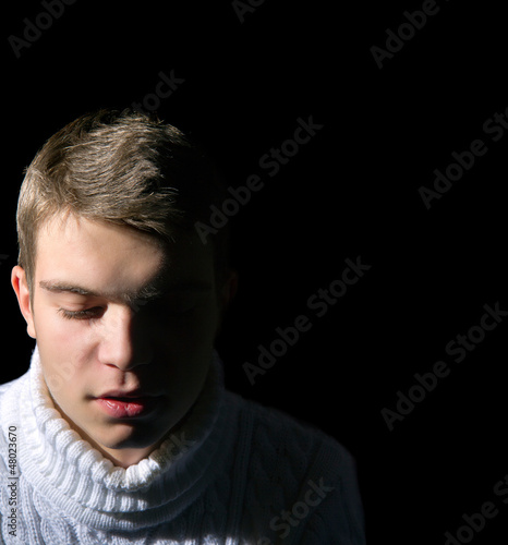 Photo: Close-up of young man on black background, low key, Close-up of young man on black background, low key,