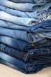 Many jeans stacked in a pile closeup