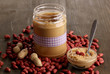 Delicious peanut butter in jar on wooden table close-up