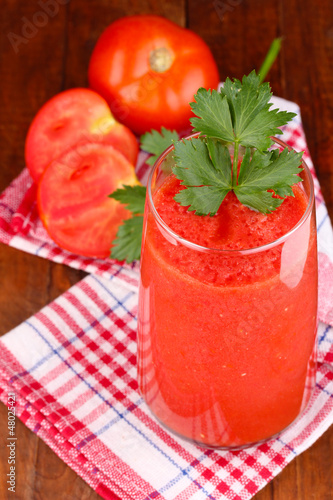 Photo: Glass of tomato juice on wooden table Glass of tomato juice on wooden table