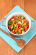 Vegetable stew in gray pot on color napkin on wooden background