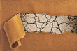 drought land and cracked ground behind torn paper