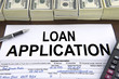 Approved loan application form and dollar bills