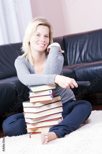 Photo: Blonde girl happily relaxing in the books. Blonde girl happily relaxing in the books.