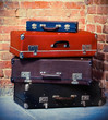 Old vintage suitcases isolated near brick wall