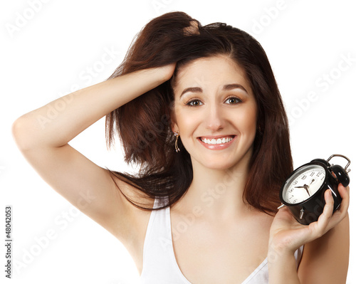 Photo: Surprised young brunette woman holding clock Surprised young brunette woman holding clock