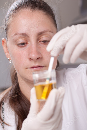 Photo: Woman making urine test Woman making urine test