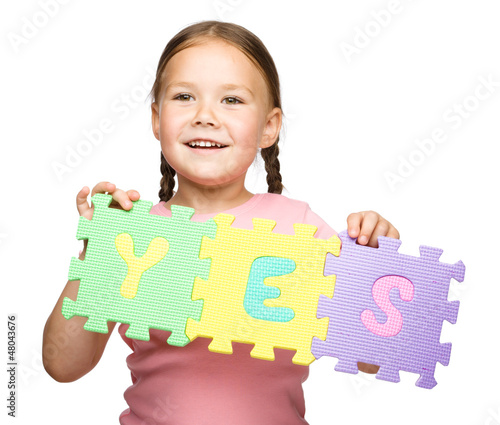 Photo: Cute little girl is holding Yes slogan Cute little girl is holding Yes slogan