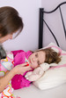 Mother check temperature of sick daughter