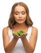 woman with spinach leaves on palms