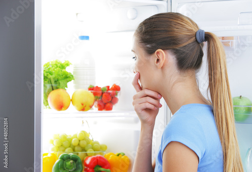 Photo: Young woman choosing food Young woman choosing food