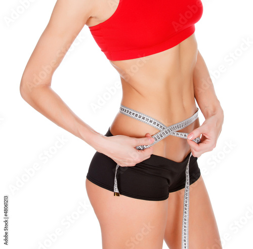 Photo: Woman measuring waist with a tape measure, isolated on white Woman measuring waist with a tape measure, isolated on white