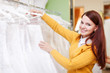 pretty young bride choosing wedding dress