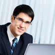 Smiling businessman working with laptop at office