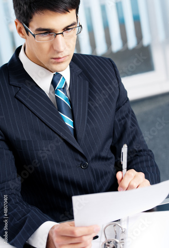 Photo: Portrait of reading businessman working at office Portrait of reading businessman working at office