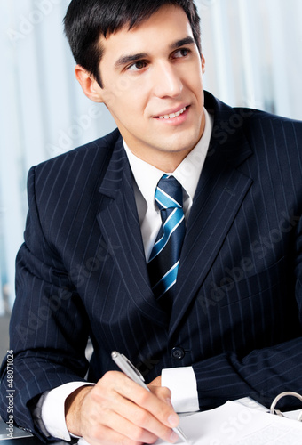 Photo: Successful businessman with documents at office Successful businessman with documents at office