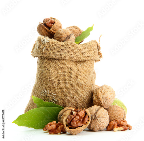 Photo: walnuts with green leaves in burlap bag, isolated on white walnuts with green leaves in burlap bag, isolated on white