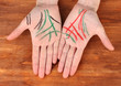 Chiromancy.Color contours on palm, on wooden background