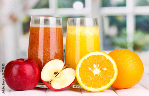 Photo: fresh fruit juices on wooden table, on window background fresh fruit juices on wooden table, on window background