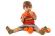 cute little boy eating tangerines, isolated on white