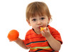 cute little boy eating tangerine, isolated on white