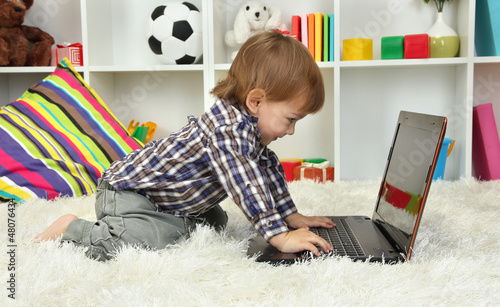Photo: cute little boy and notebook in room cute little boy and notebook in room