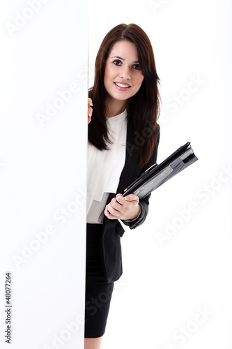 Photo: Junge Büro Dame blickt freundlich hinter Wand vor Junge Büro Dame blickt freundlich hinter Wand vor