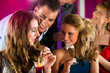 People in club or bar drinking cocktails