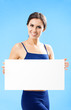 Woman in fitnesswear showing signboard, over blue