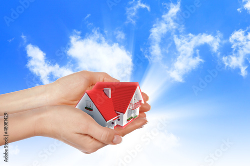 Photo: the house in hands on blue sky the house in hands on blue sky