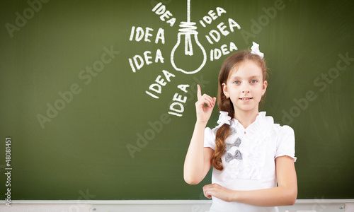 Photo: Scoolgirl standing near blackboard Scoolgirl standing near blackboard
