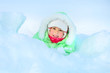Cheerful girl lying in deep snow drift