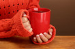 hands holding mug of hot drink, close-up