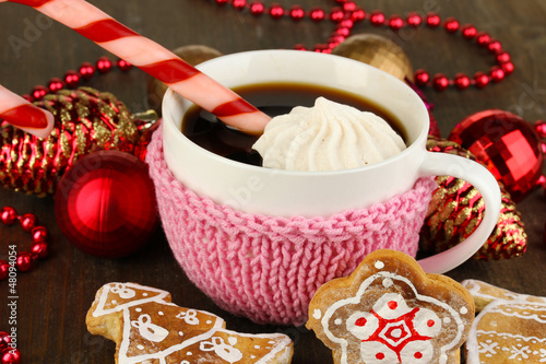 Photo: Cup of coffee with Christmas sweetness on wooden table close-up Cup of coffee with Christmas sweetness on wooden table close-up
