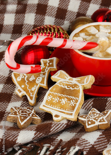 Photo: Cup of coffee with Christmas sweetness on plaid close-up Cup of coffee with Christmas sweetness on plaid close-up