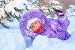 Cheerful little girl playing in a snowy forest.