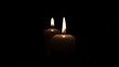 Two romantic  burning candles in dark .