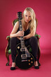 Beautiful blond sitting with electric guitar